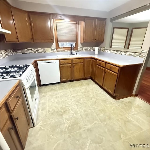 kitchen with white appliances, sink, and tasteful backsplash