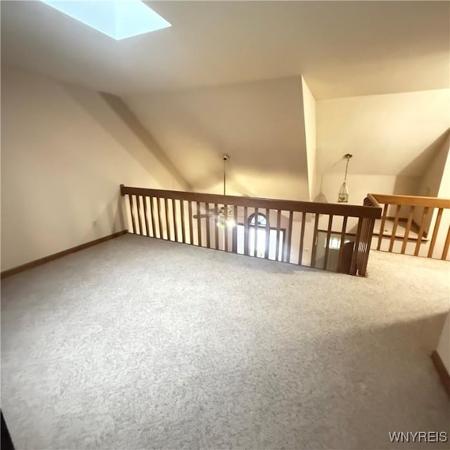 bonus room featuring vaulted ceiling with skylight and carpet floors