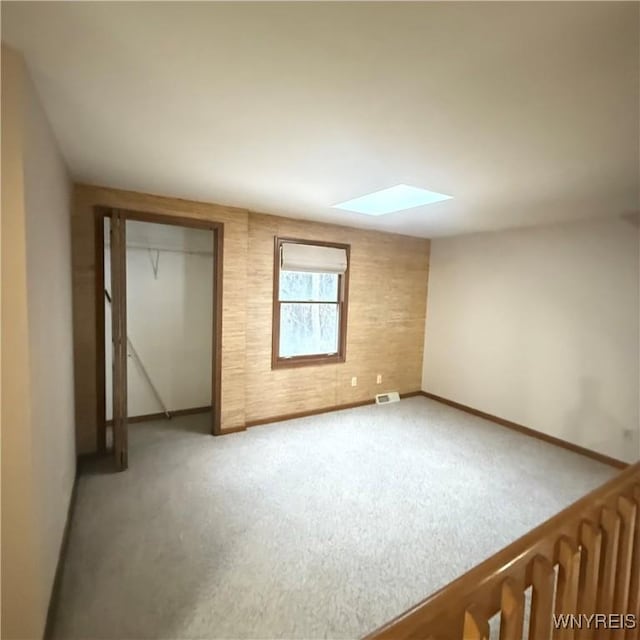 unfurnished bedroom featuring carpet flooring and a skylight