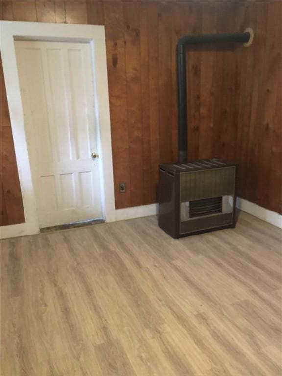 unfurnished living room featuring light wood-type flooring and wood walls