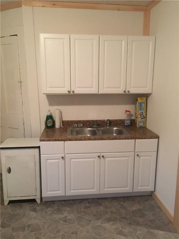 bar with white cabinets and sink