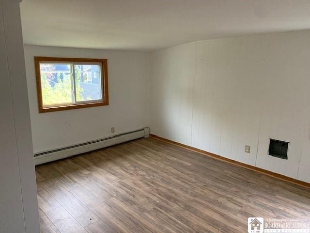 spare room with hardwood / wood-style floors and a baseboard radiator