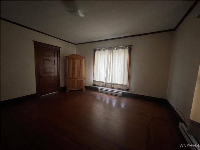 spare room with dark hardwood / wood-style floors, crown molding, and a baseboard heating unit