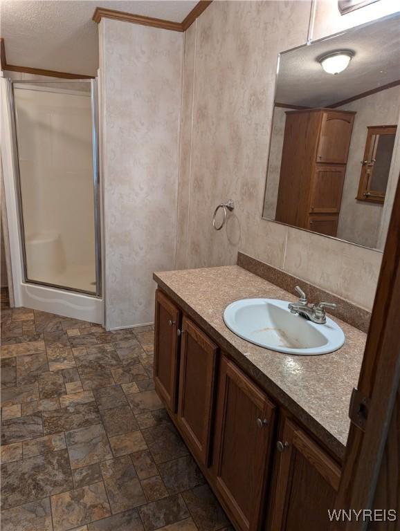 bathroom with vanity, walk in shower, and crown molding