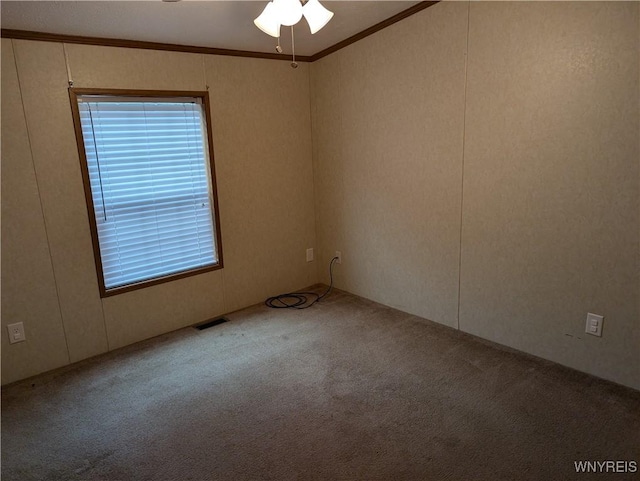 spare room with light carpet, ceiling fan, and ornamental molding