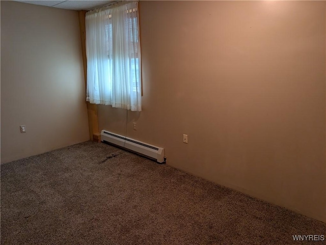 empty room featuring carpet and a baseboard heating unit