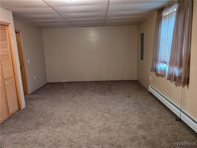 unfurnished room featuring carpet flooring, electric panel, a baseboard radiator, and a drop ceiling