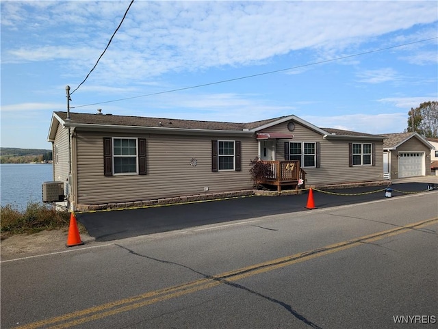 manufactured / mobile home with a garage and a water view