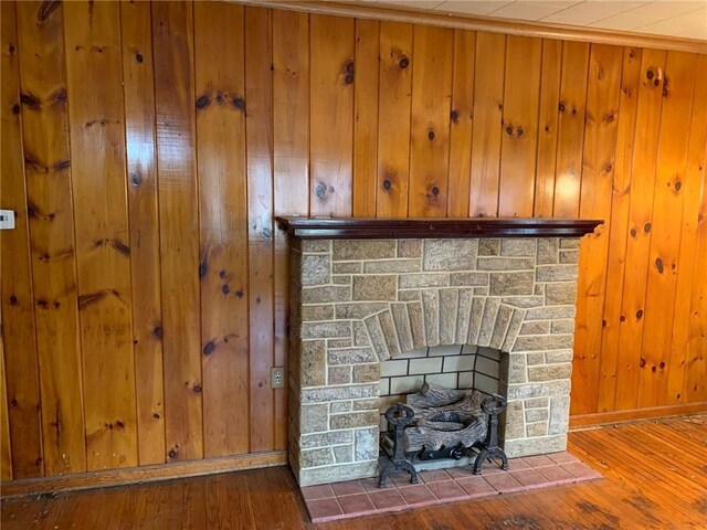 details with a fireplace, wood-type flooring, and wooden walls