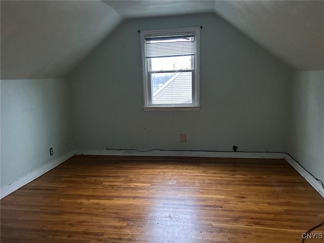 additional living space with dark hardwood / wood-style flooring and vaulted ceiling