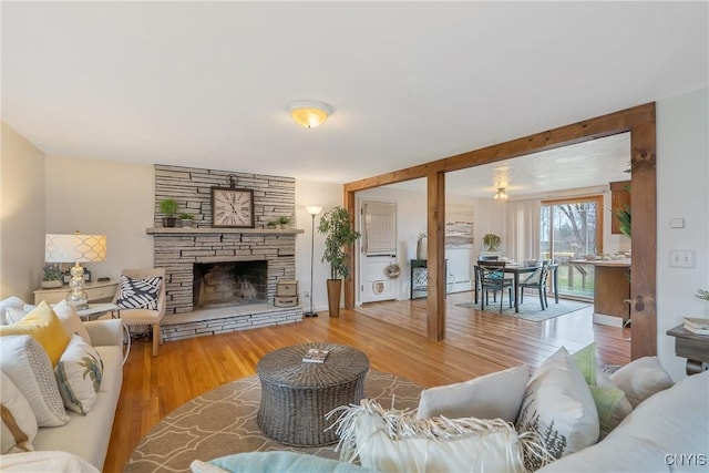 living room with a stone fireplace and hardwood / wood-style floors