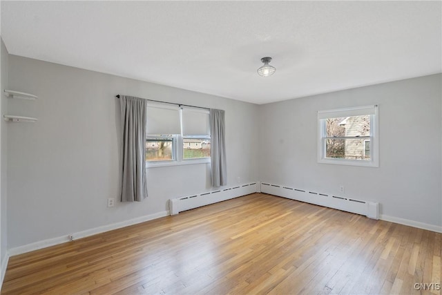 spare room with hardwood / wood-style flooring and a baseboard heating unit