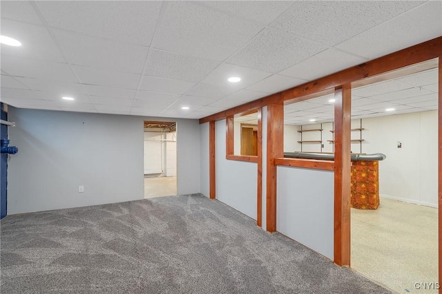 basement featuring a drop ceiling and carpet floors