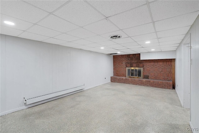 unfurnished living room with light carpet, a paneled ceiling, a brick fireplace, and a baseboard heating unit