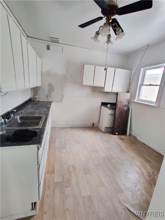 508 Howard St, Buffalo, NY 14206 - kitchen featuring white cabinets, ceiling fan, light wood-style floors, and dark countertops