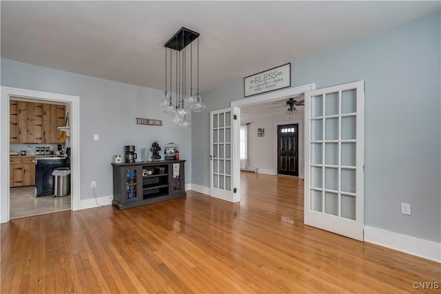 unfurnished dining area with french doors, light hardwood / wood-style flooring, and ceiling fan