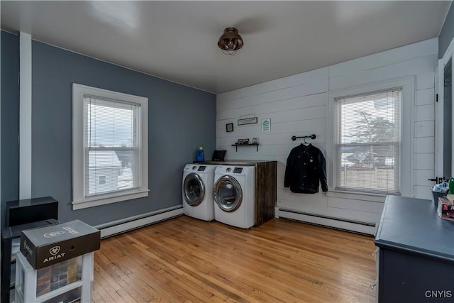 laundry room with hardwood / wood-style floors, a baseboard heating unit, and washing machine and clothes dryer