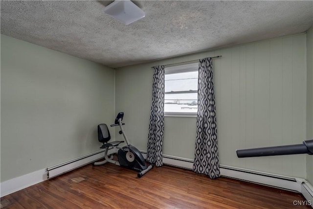 workout area with hardwood / wood-style floors, a textured ceiling, and a baseboard radiator