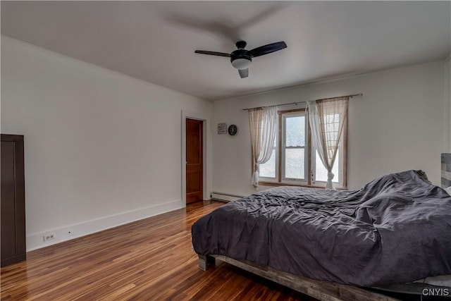 bedroom with hardwood / wood-style flooring, ceiling fan, and baseboard heating