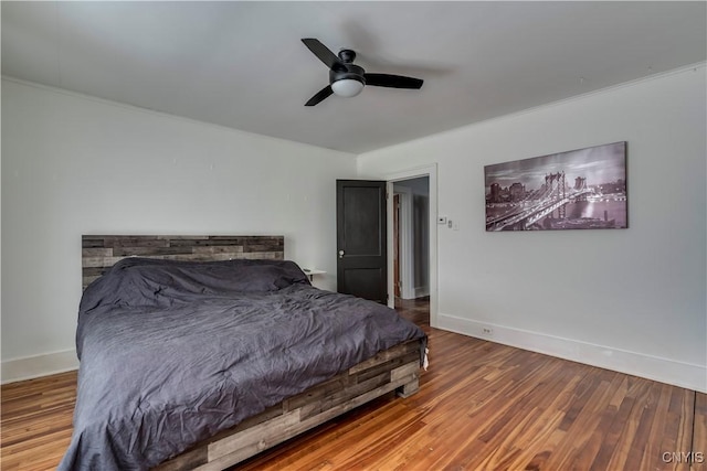 bedroom with hardwood / wood-style floors, ceiling fan, and crown molding