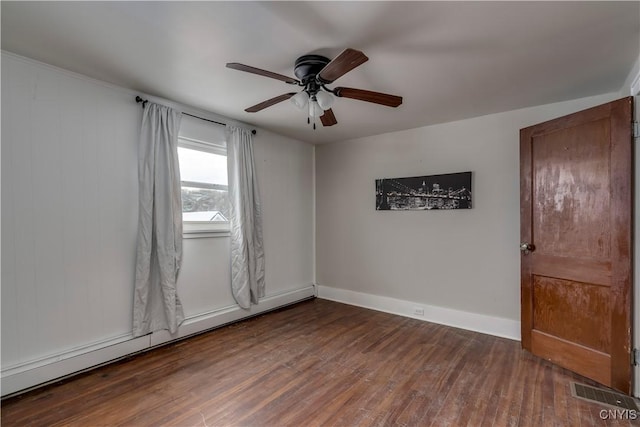 empty room featuring dark hardwood / wood-style floors, ceiling fan, and baseboard heating