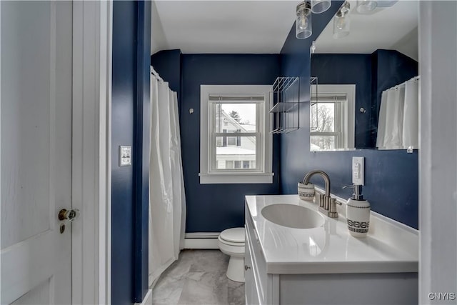 bathroom featuring vanity, toilet, baseboard heating, and ceiling fan