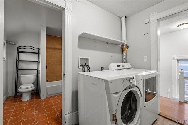 laundry room with dark hardwood / wood-style floors and washing machine and clothes dryer