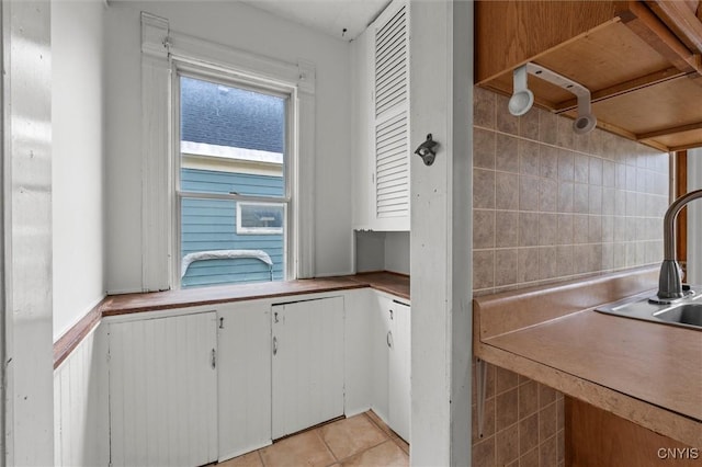 kitchen with sink, tile walls, and light tile patterned flooring