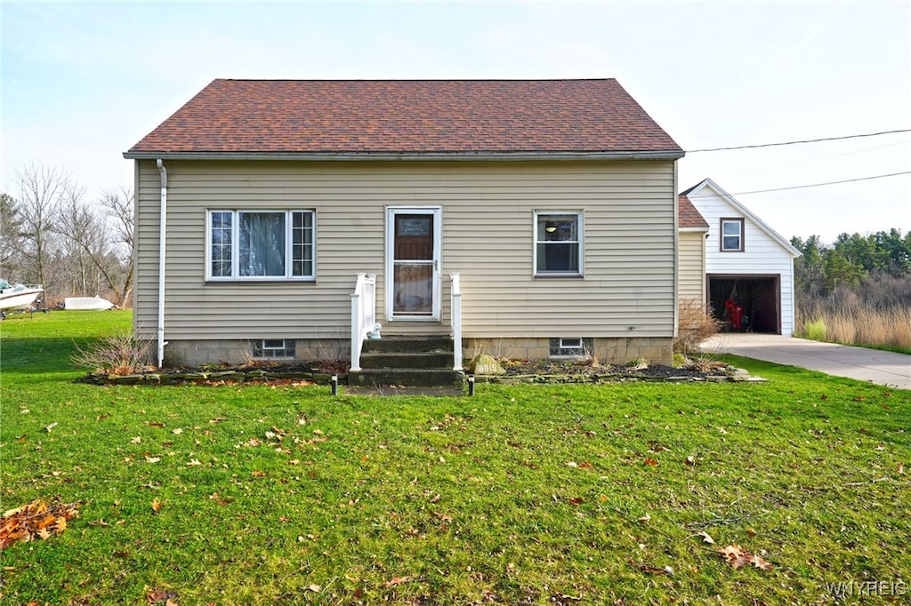 view of front of property with a garage, a front lawn, and an outdoor structure