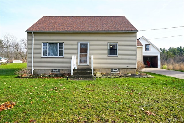 view of front of property with a garage, a front lawn, and an outdoor structure