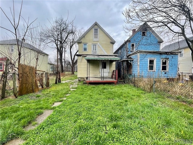 rear view of property featuring a lawn and a wooden deck