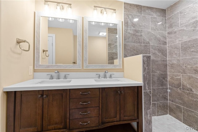 bathroom with tiled shower and vanity