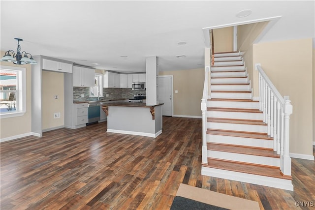 kitchen with backsplash, dark hardwood / wood-style flooring, and stainless steel appliances