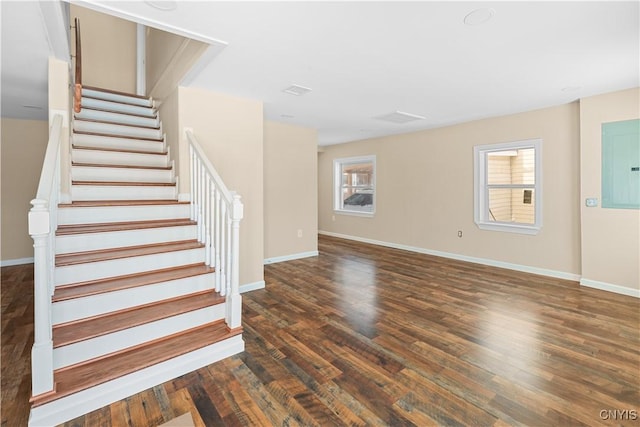 staircase with hardwood / wood-style flooring and electric panel