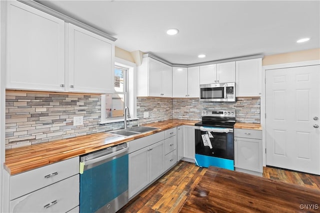 kitchen featuring butcher block counters, white cabinetry, and stainless steel appliances