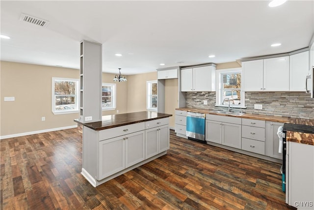 kitchen featuring wood counters, dark hardwood / wood-style flooring, white cabinets, and appliances with stainless steel finishes