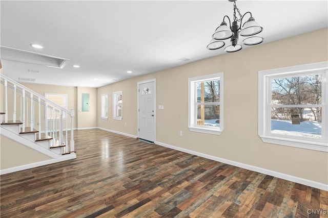 foyer entrance with dark wood-type flooring and a notable chandelier