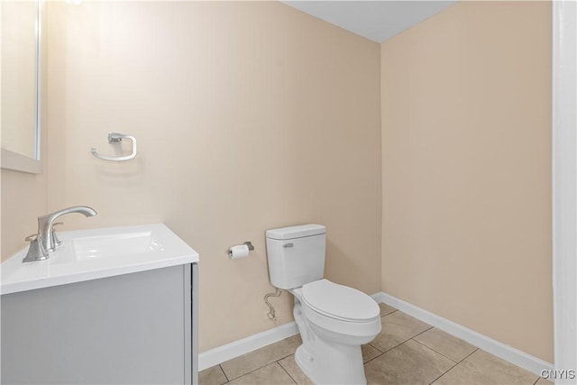 bathroom with toilet, vanity, and tile patterned floors