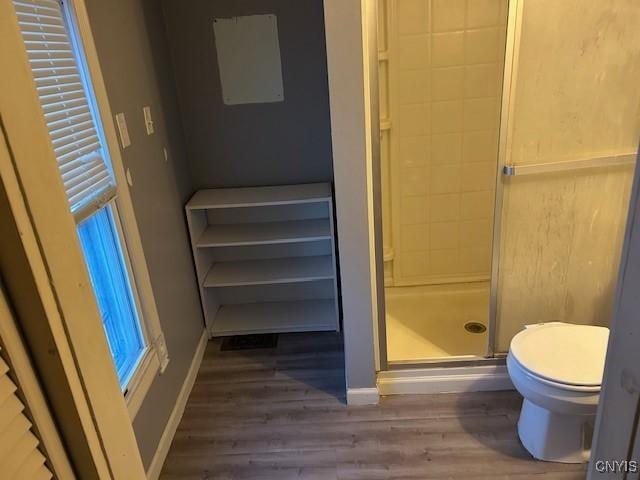 bathroom featuring hardwood / wood-style floors, toilet, and walk in shower