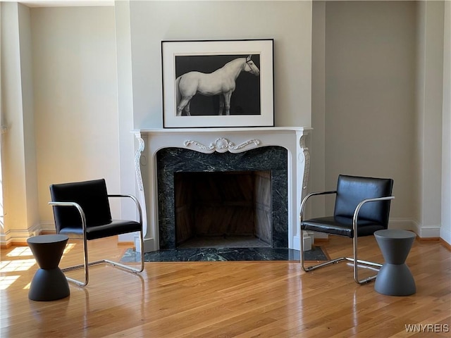 sitting room featuring a premium fireplace and hardwood / wood-style floors