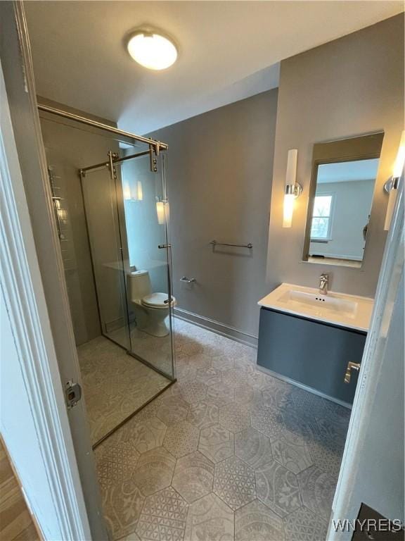 bathroom featuring vanity, toilet, and a shower with door