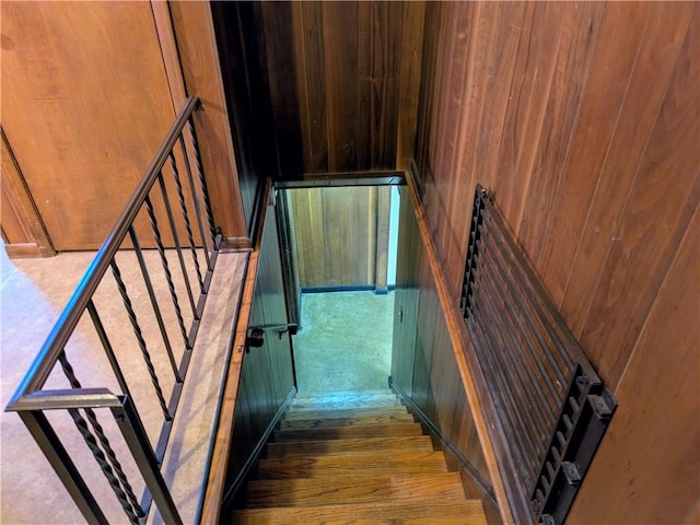 staircase with hardwood / wood-style floors and wood walls