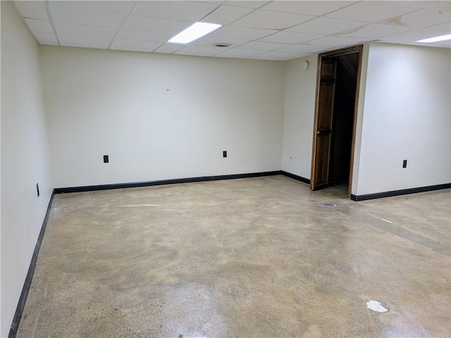 unfurnished room featuring a drop ceiling