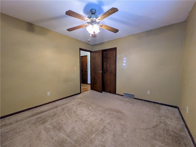 spare room with ceiling fan and light colored carpet