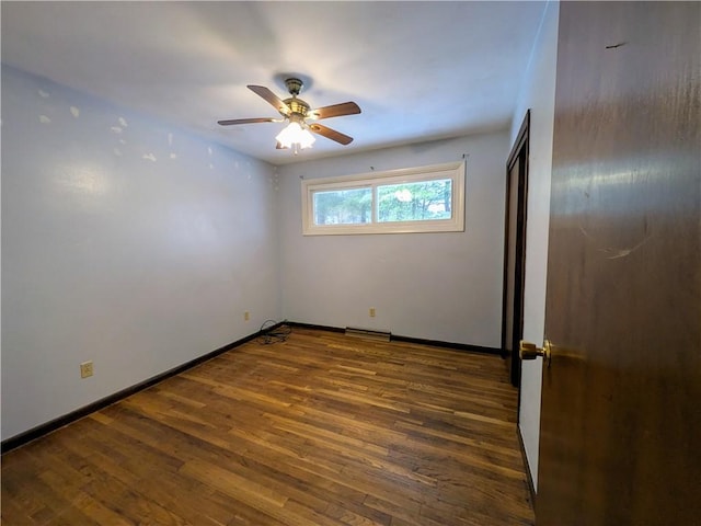 empty room with dark hardwood / wood-style floors and ceiling fan