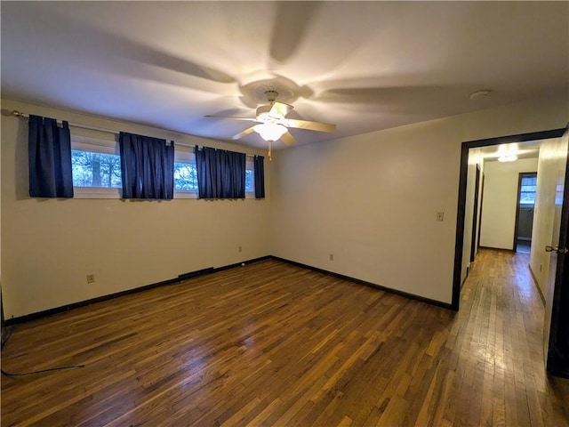 empty room with hardwood / wood-style floors and ceiling fan