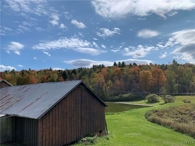 view of outbuilding with a water view and a yard