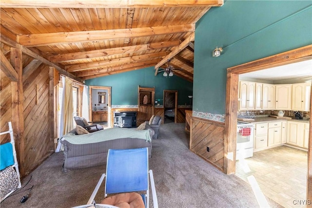 living room featuring a wood stove, lofted ceiling with beams, wooden ceiling, and wood walls