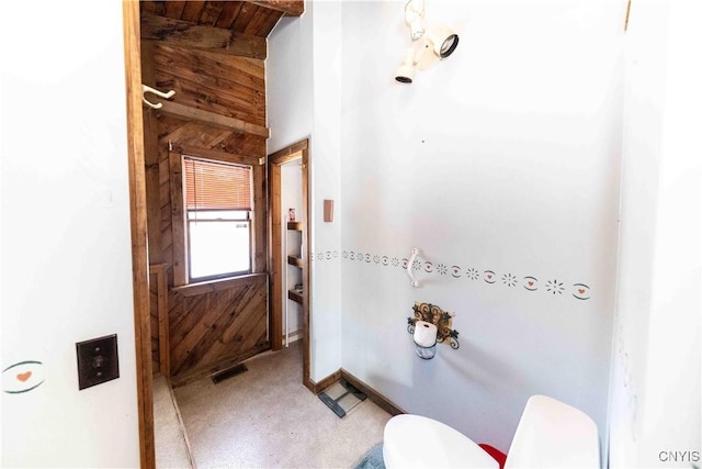 bathroom with wooden walls and toilet