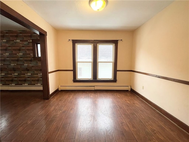 unfurnished room with dark wood-type flooring and a baseboard heating unit